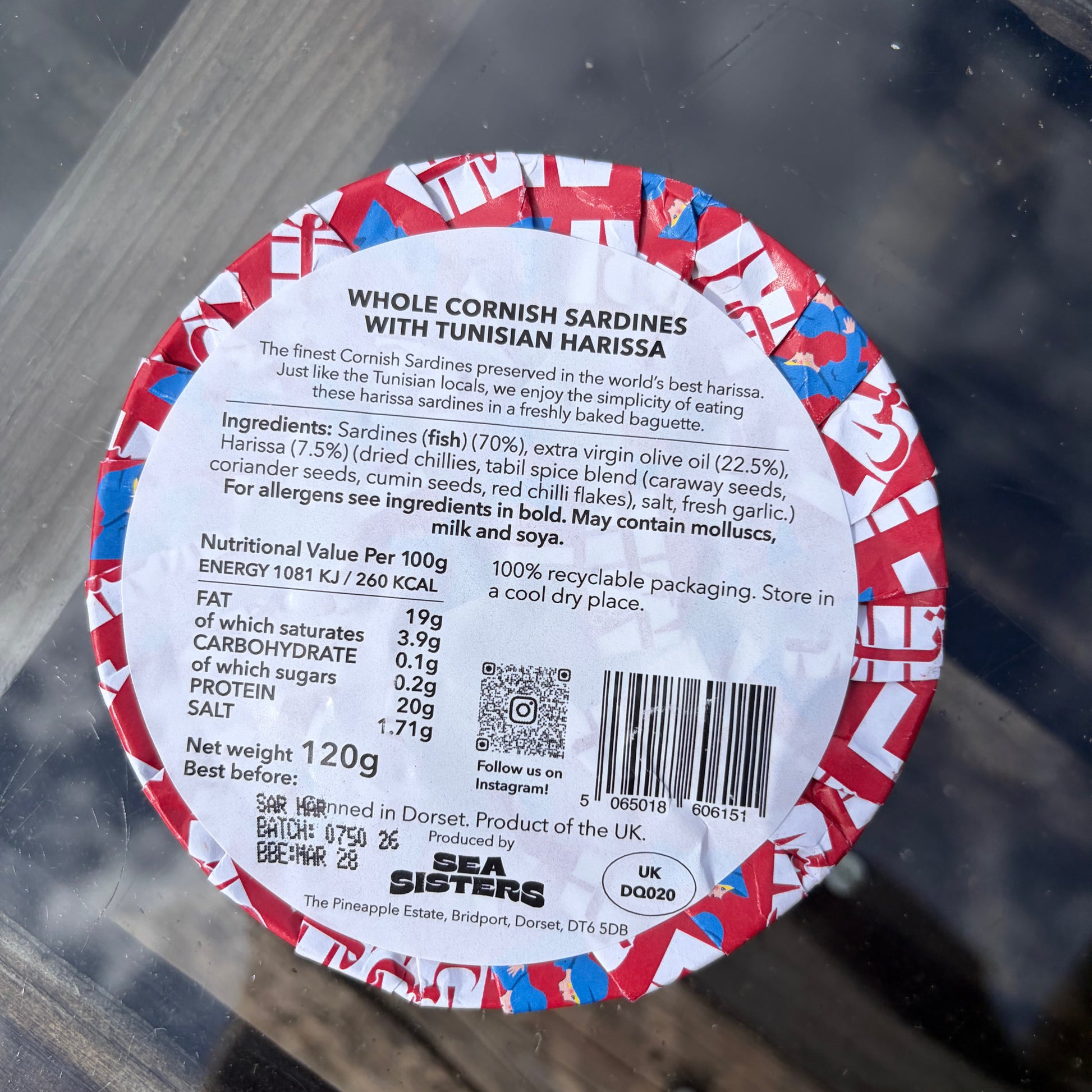 Label of whole cornish sardines with Tunisian harissa on a glass surface