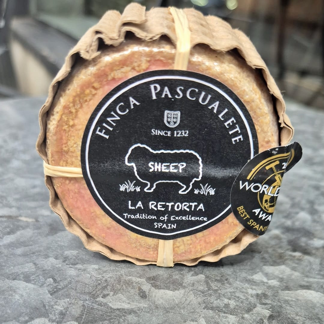 Sheep cheese with 'Finca Pascualete' label on a stone surface