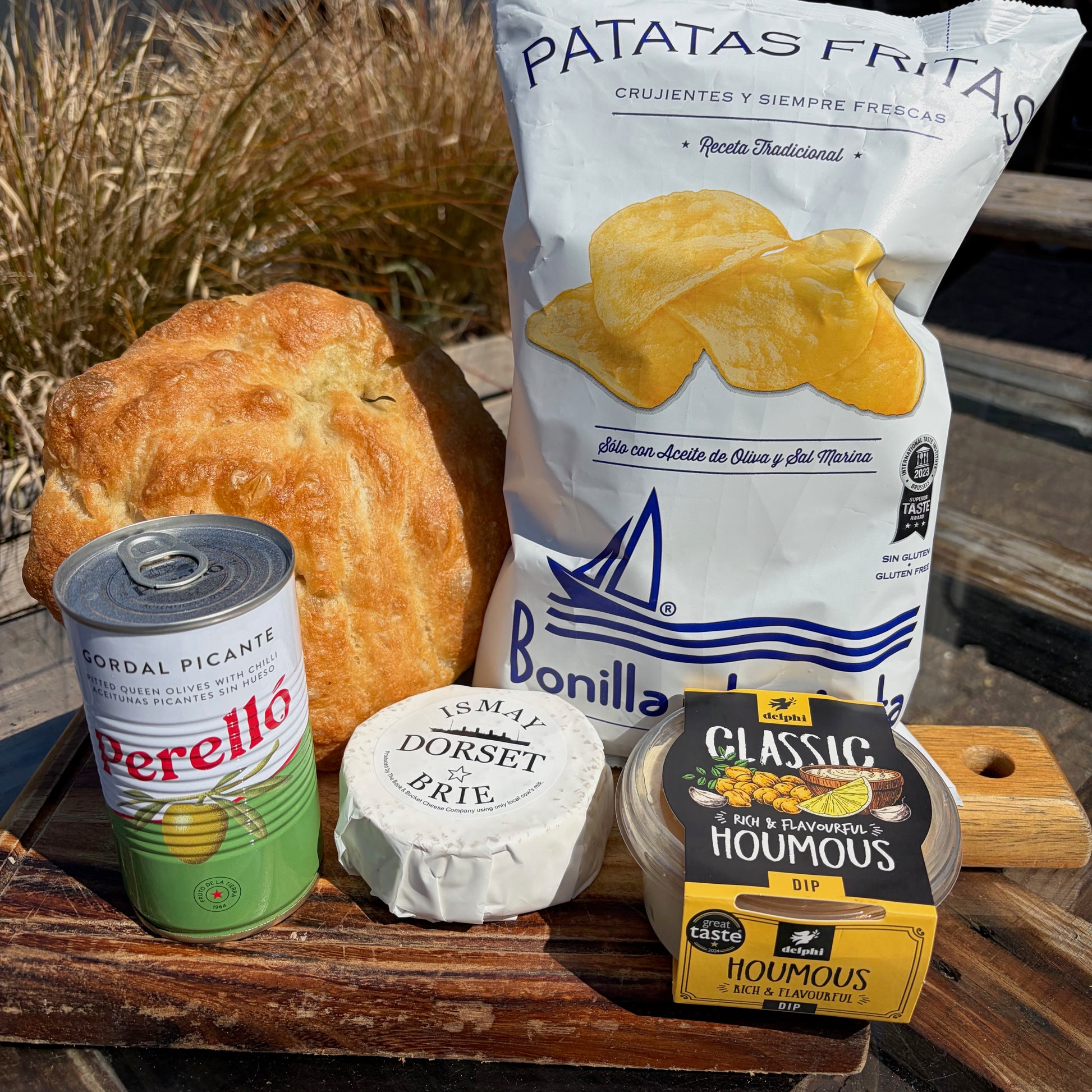 A selection of Deli items a bakes arranged on a wooden board.
