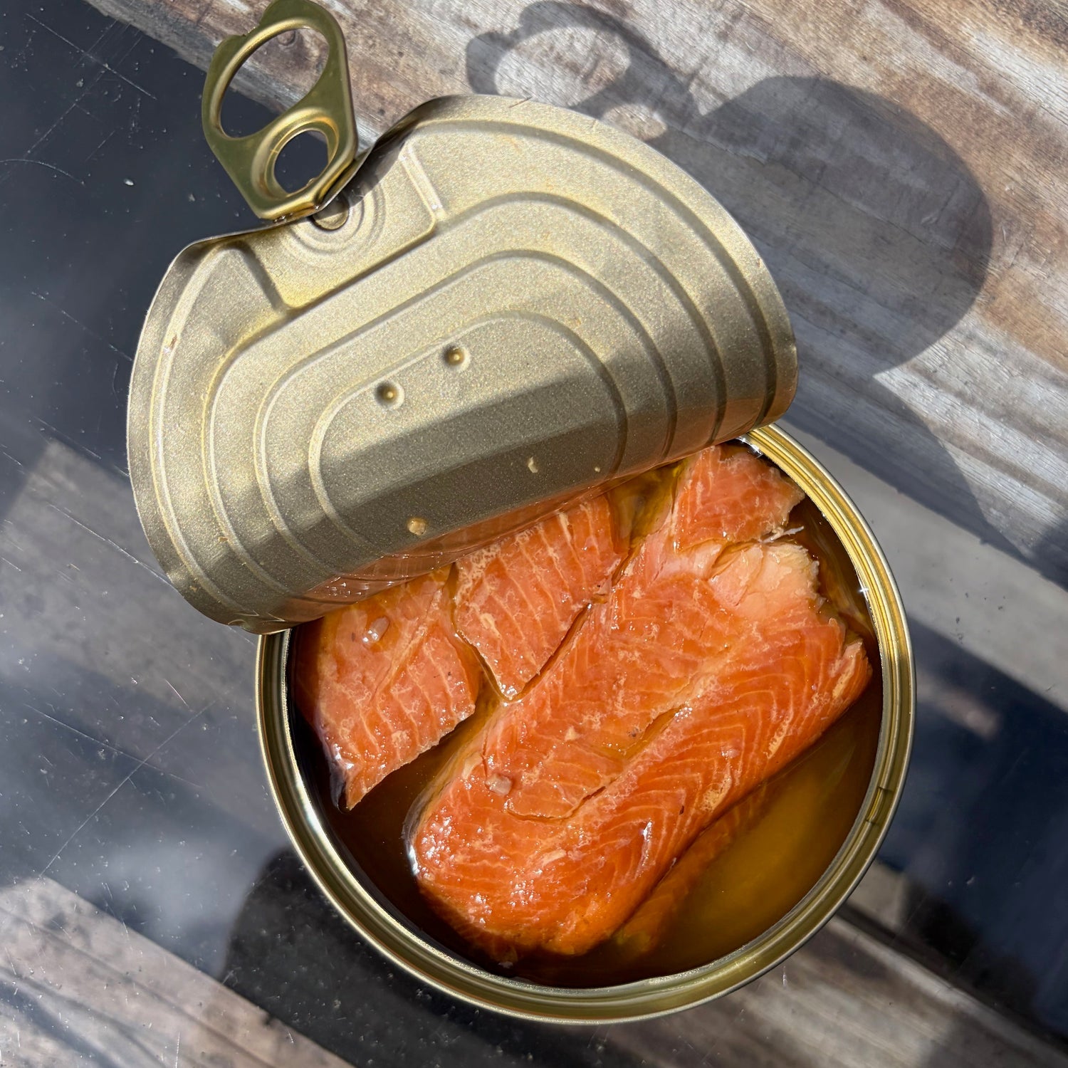 Open tin of sea sisters smoked rainbow trout on a wooden surface