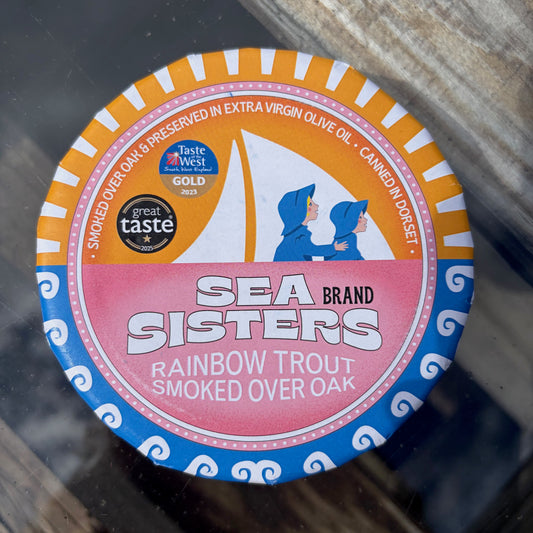 Sea Sisters rainbow trout smoked over oak tin on a glass surface